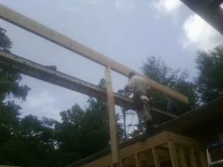 Carpenter setting a ridge beam over a new addition frame — Ice Dam Removal by Roofing Brothers in Wallpack Center
