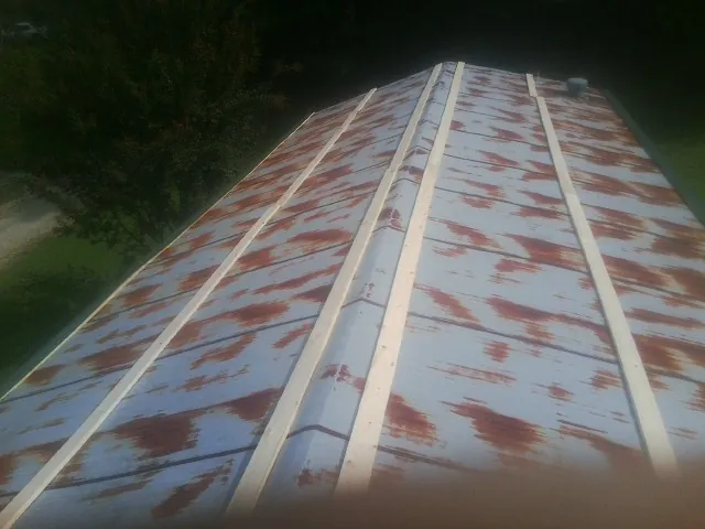 Rusted metal roof panels with new wood purlins before replacement — Storm Damage Roof Repair in Wallpack Center by Roofing Brothers