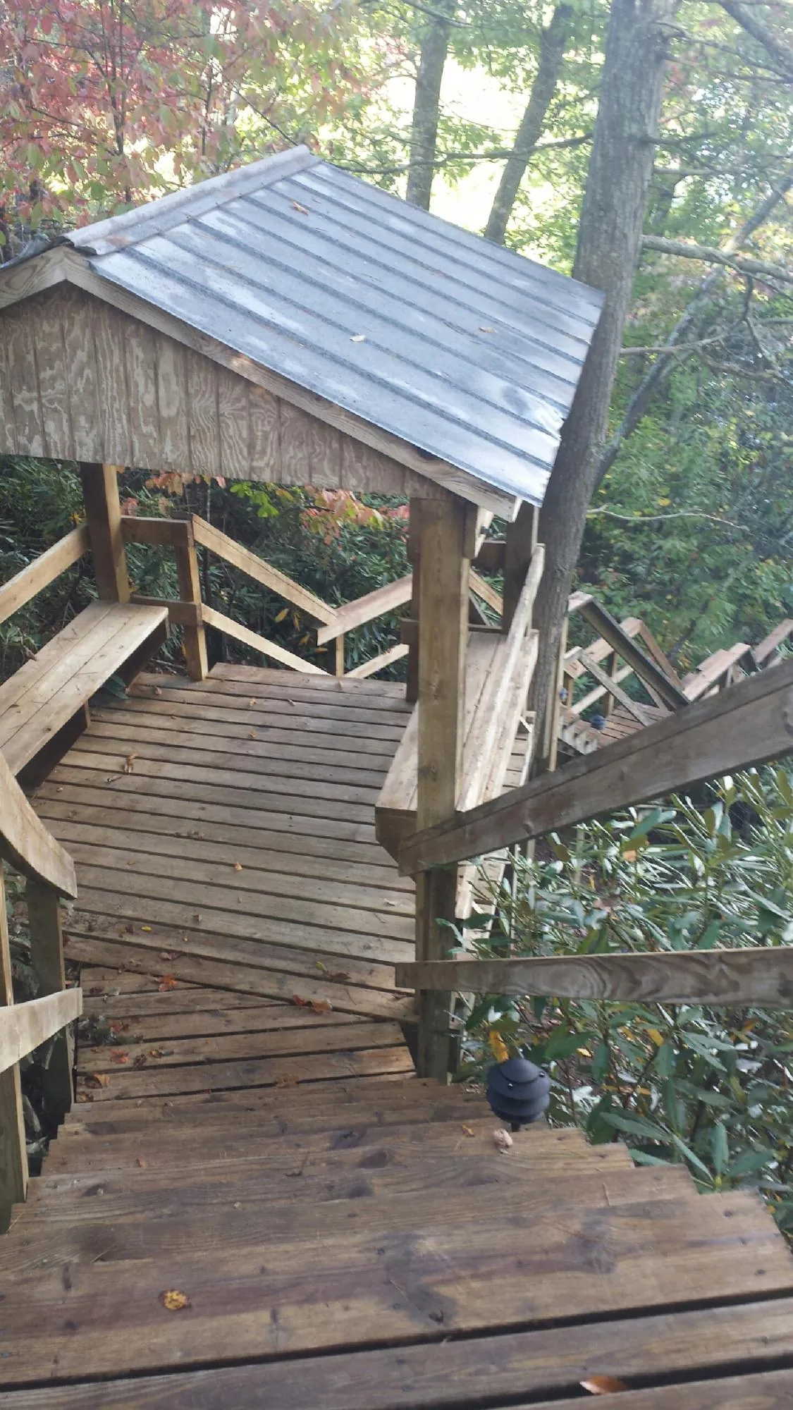 Metal roofed shelter over wooden steps on a wooded walkway — Skylight Repair & Installation work by our crew in Wallpack Center