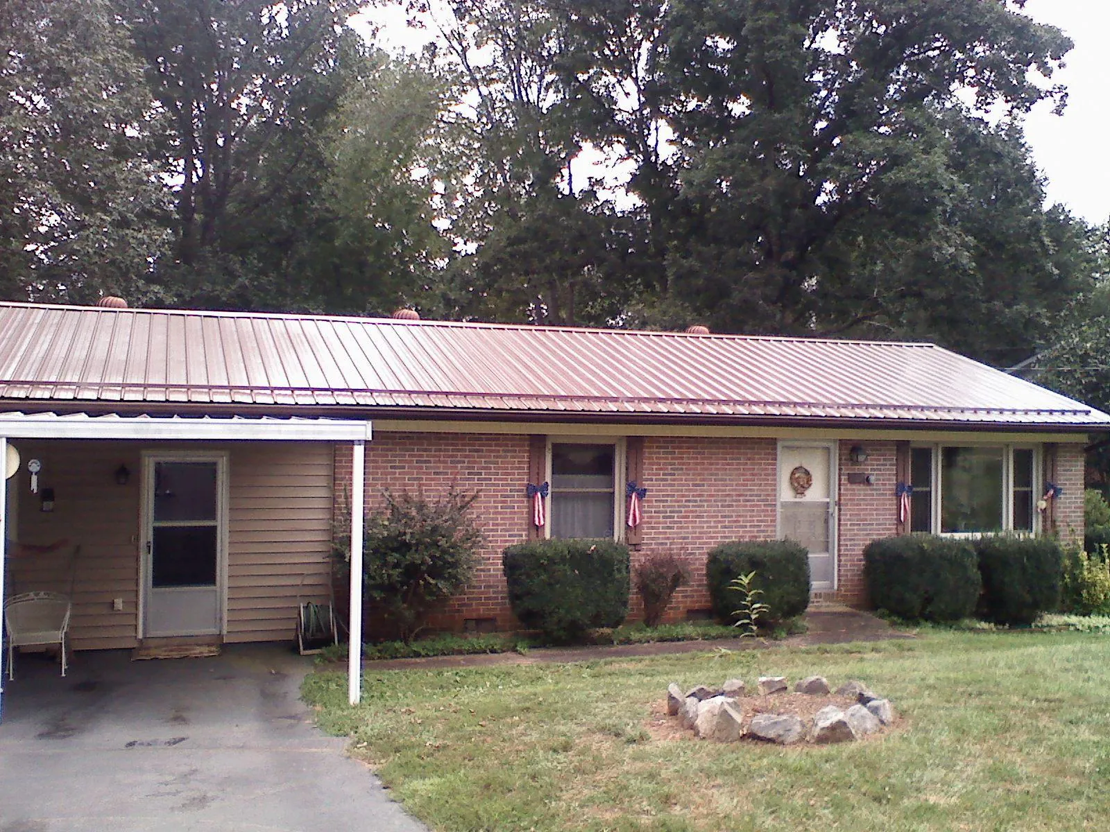 Bronze metal roof and carport on a brick ranch home — Roof Repair work by our crew in Wallpack Center